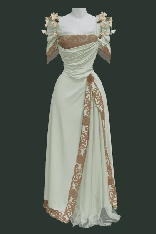The front of a 3 dimensional rendering of the Worth Dress, showing its separate mint green skirt and bodice with surface decorations of cotton lace and morning glory flowers. The neckline features silk netting and three-inch wide lace with an irregular edge. The lace is also doubled on the bodice to create a wider effect. Draped, asymmetrical silk crepe de chine on the bodice and skirt flows over the garment’s highly structured base layer.