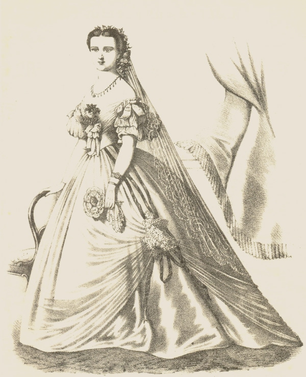 A woman modelling a large hooped dress. A long veil hangs from the back of her head.