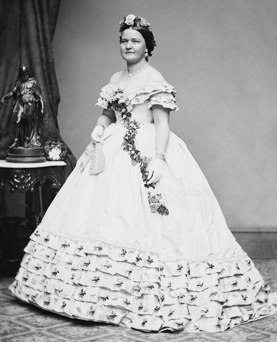 First Lady, Mary Todd Lincoln, in a flower garlanded ball gown.