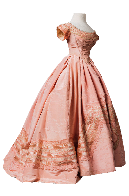 A pale pink evening dress from the 1860s thought to have been made in Italy. It has a tightly fitted bodice with a low neckline and short sleeves. The skirt is large and triangular, made of wedge-shaped panels rather than square, to create a full skirt at the hem with less bulk at the waist.